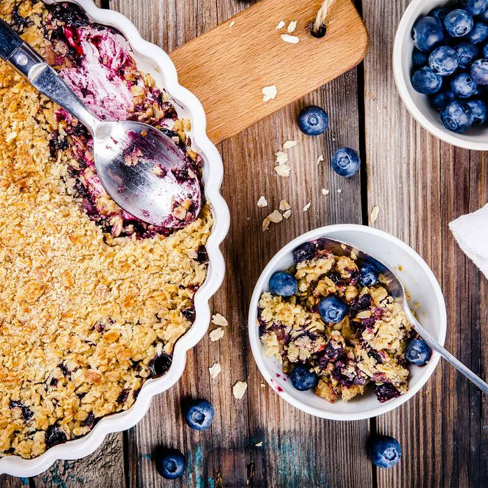 "Homemade blueberry crumble flatlay on table"
