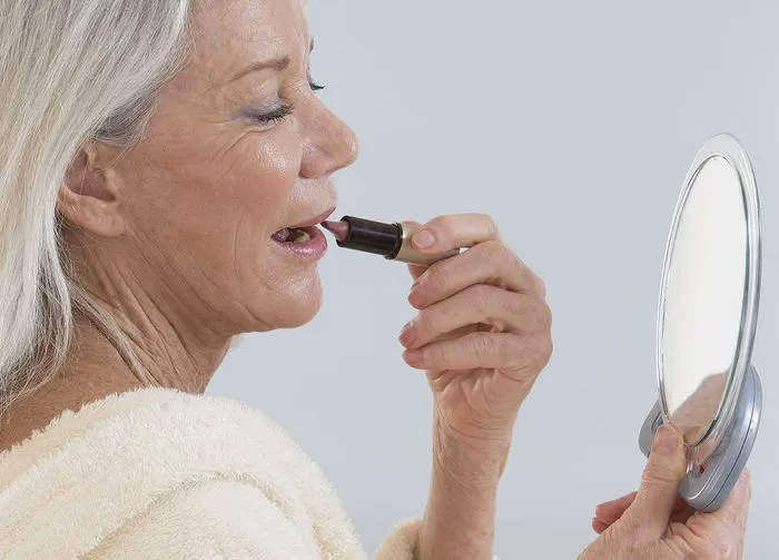 older-woman-applying-lipstick