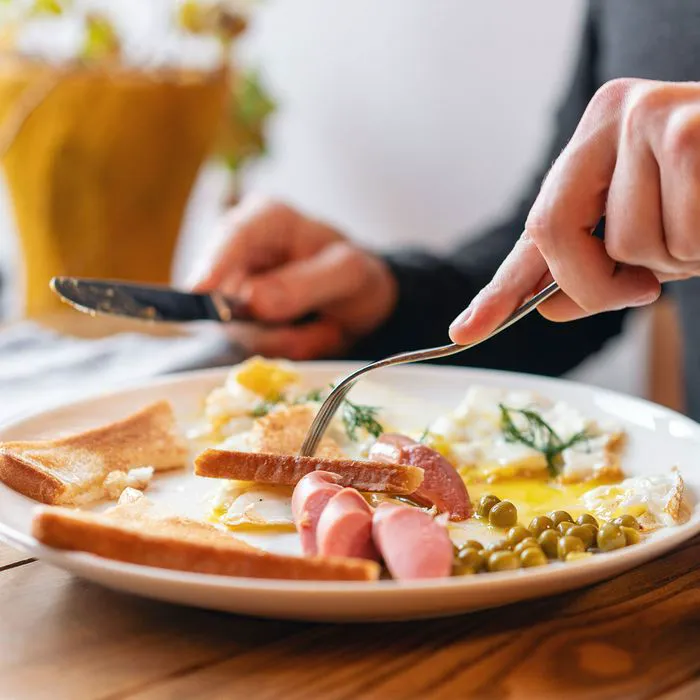 "Person enjoying a hearty breakfast"