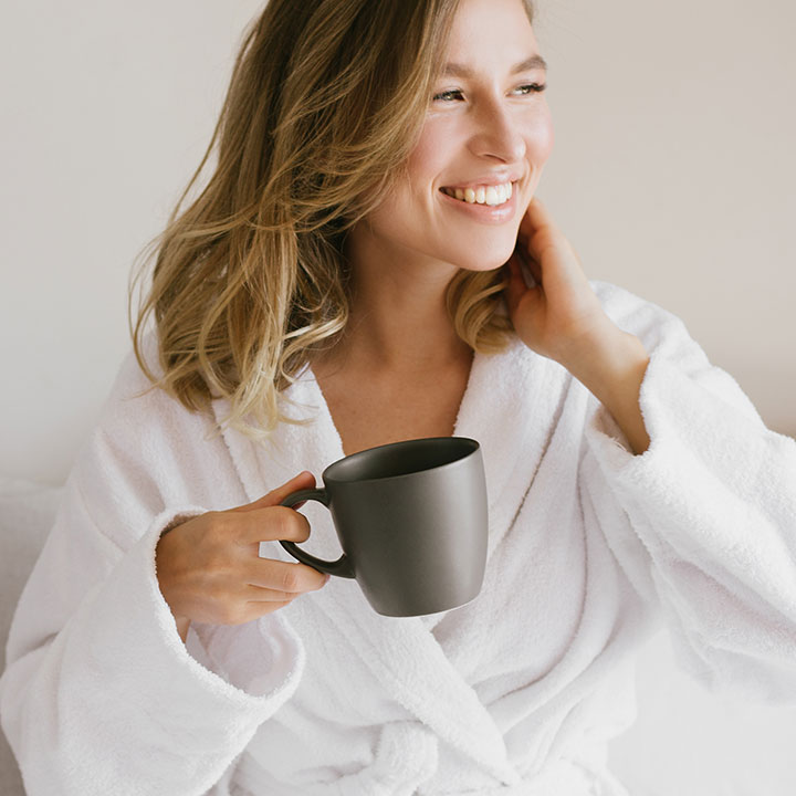 woman holding coffee and smiling
