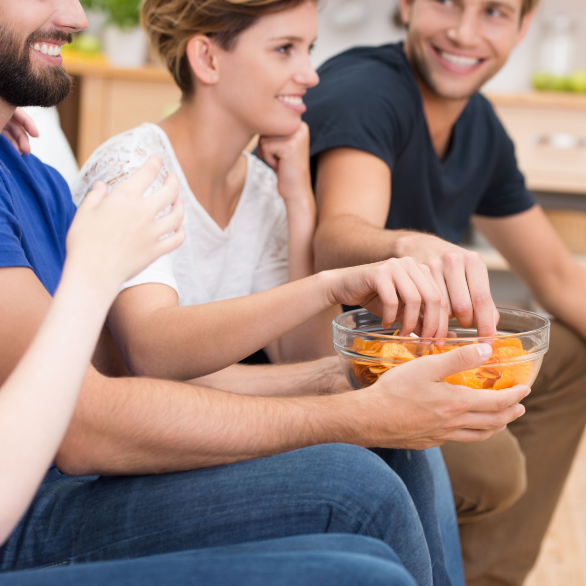 friends eating from a bowl of potato chips