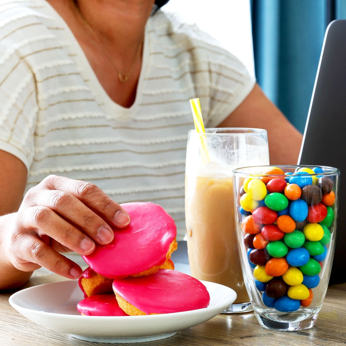 woman eating donuts m&ms and coffee