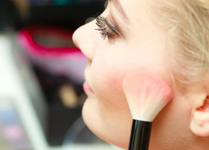 blonde-woman-applying-blush