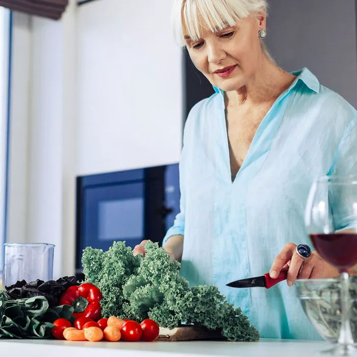 Middle-aged woman preparing dinner in the kitchen.