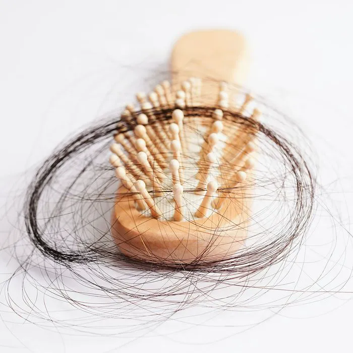 "Wooden hairbrush with pulled-out strands of hair"