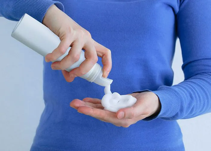 heavy hair mousse dispensing into a hair