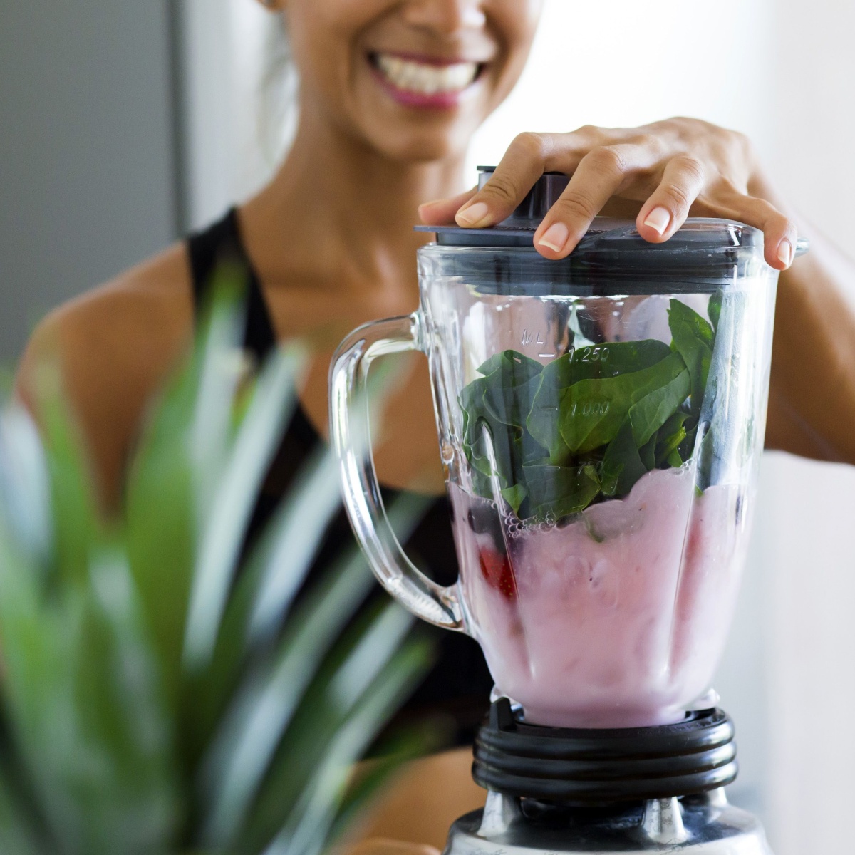 woman making smoothie with spinach