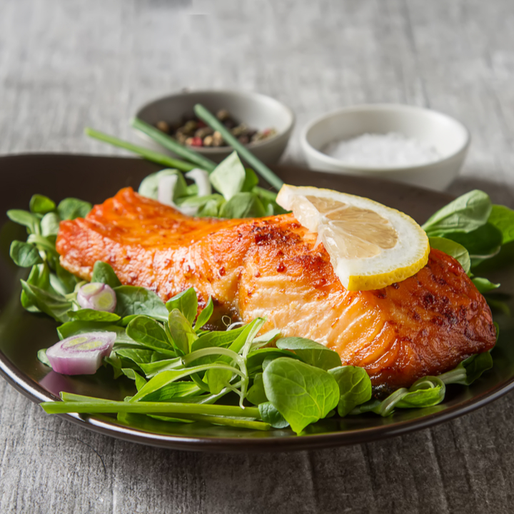 salmon on plate of greens