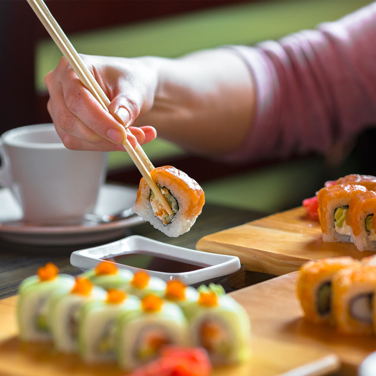 woman eating salmon sushi rolls