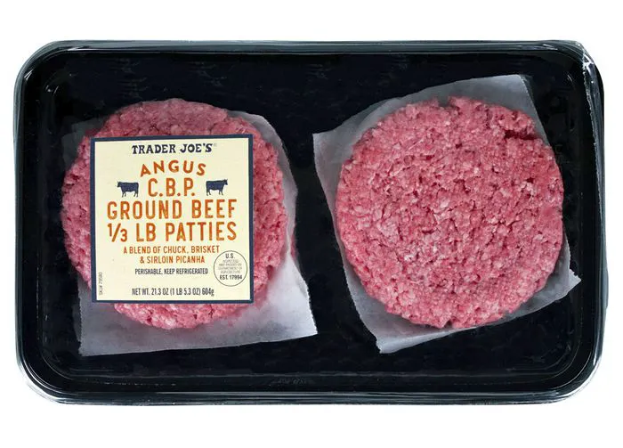 Trader Joe's Angus beef patties on a wooden cutting board.