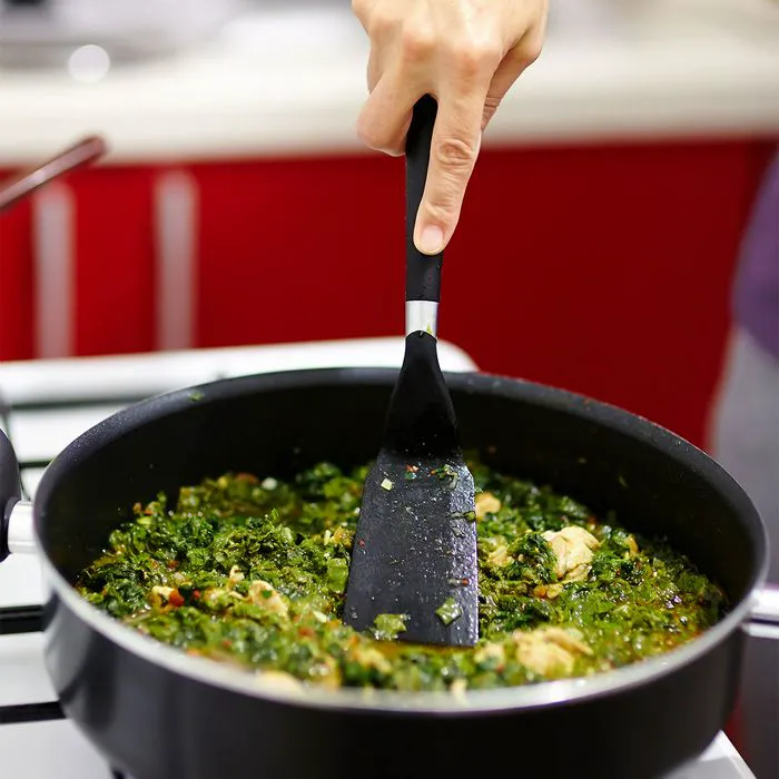 Spinach and dark leafy greens sautéing in a pan.