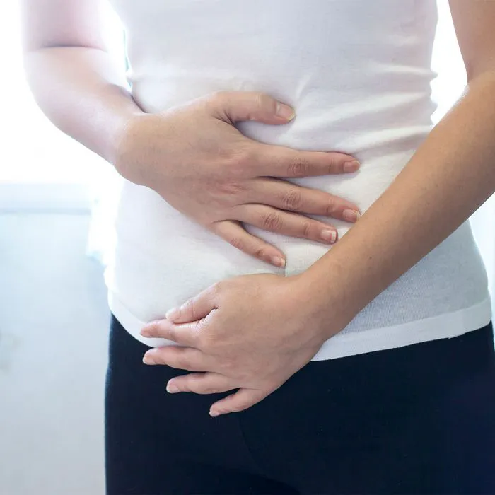 "Woman experiencing stomach pain in the bathroom"