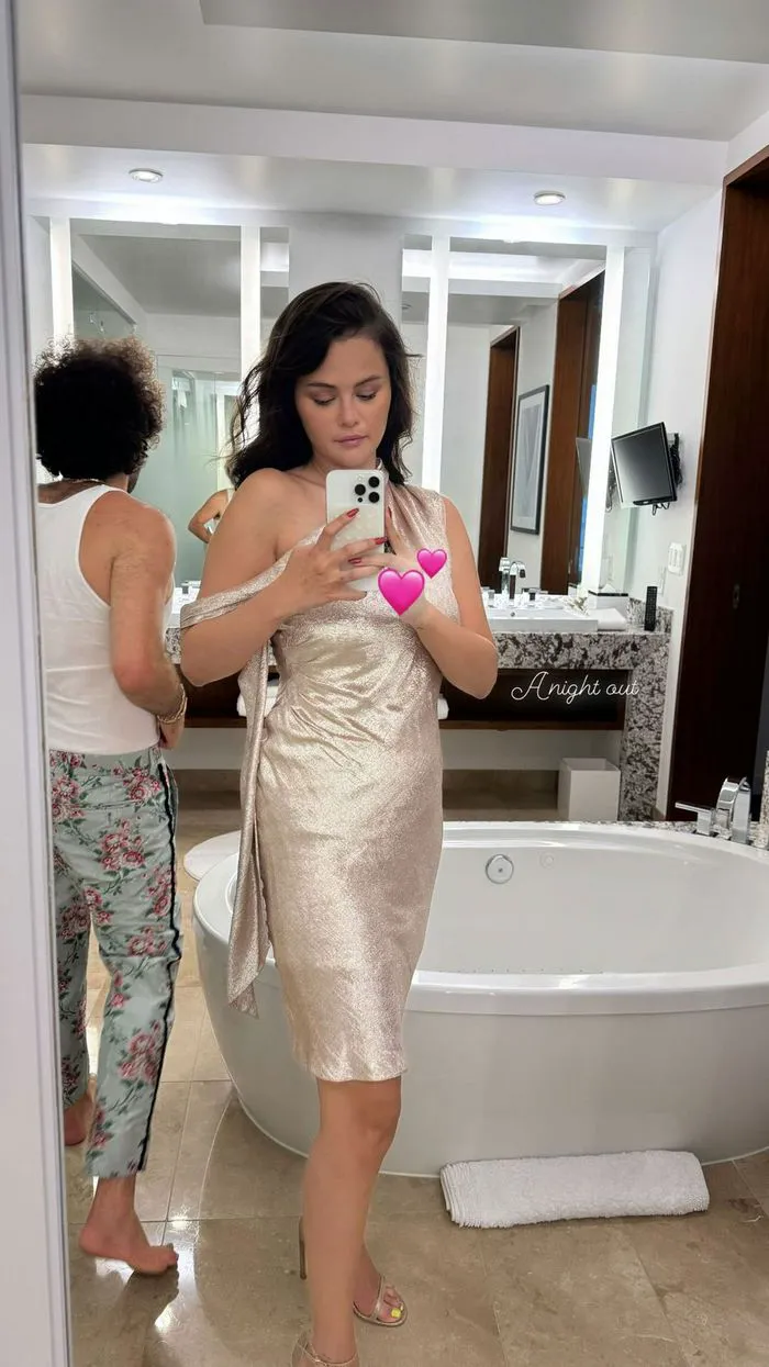Selena Gomez mirror selfie coverin ring finger with hearts