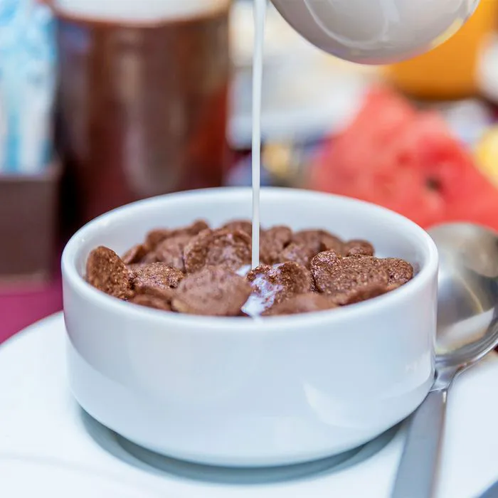Pouring milk into a bowl of bran cereal