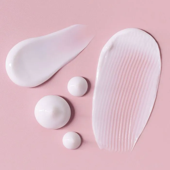 Close-up of moisturizer texture on pink background.