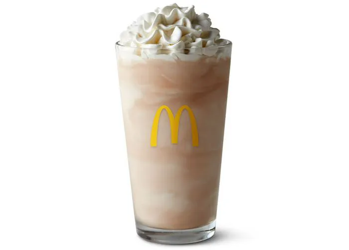 McDonald's chocolate shake in a clear cup with whipped cream.