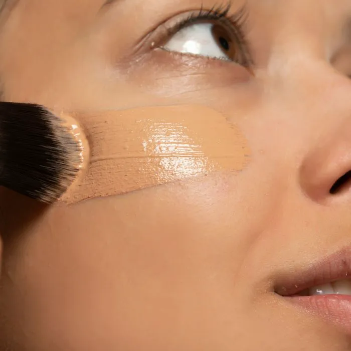 "A woman applying makeup with a focus on natural beauty"
