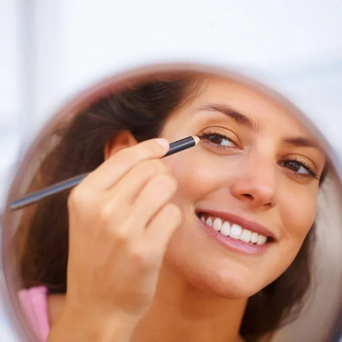 "A woman demonstrating proper makeup techniques"