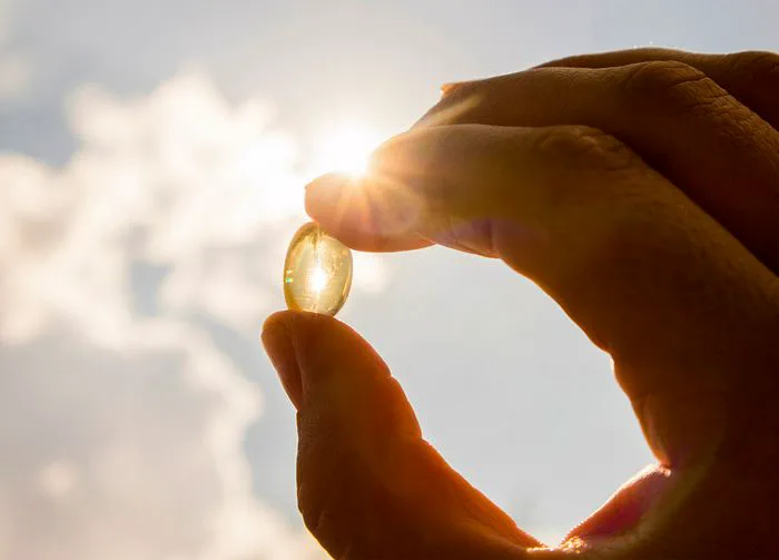 hand holding up vitamin d pill