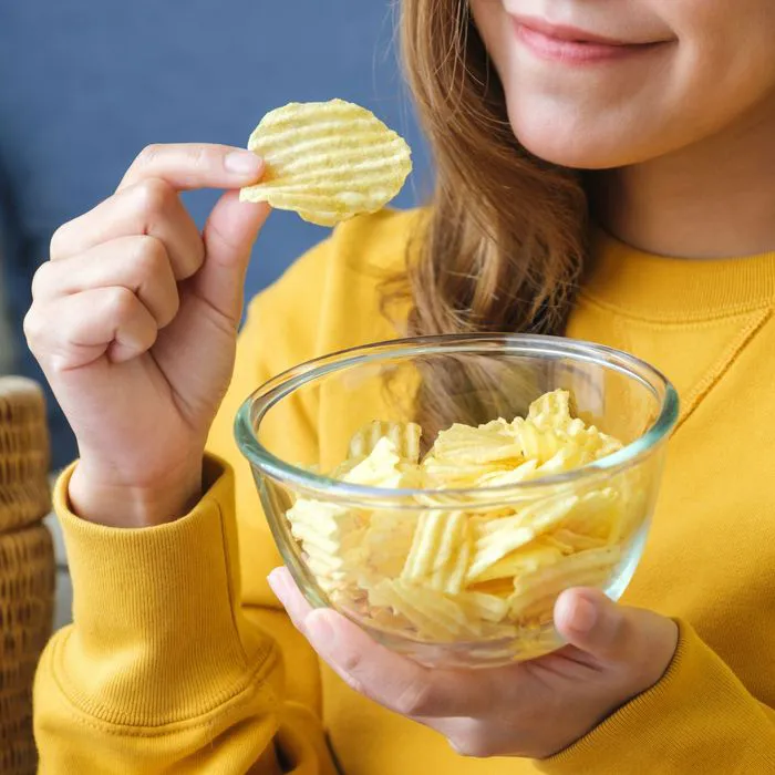 woman snacking on potato chips