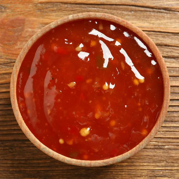 Sweet and sour sauce in a glass container.