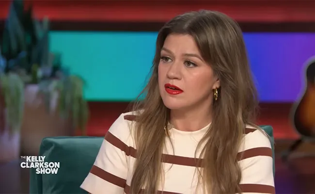 Kelly Clarkson wearing a striped dress on The Kelly Clarkson Show