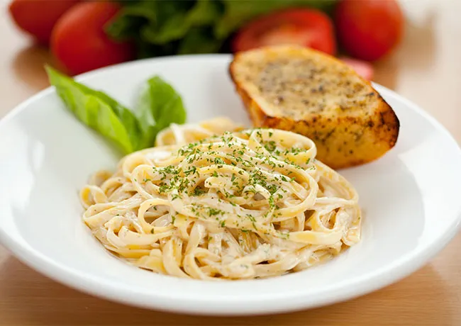 Creamy fettuccine alfredo served with garlic bread