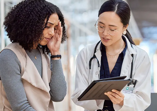 Worried woman discussing health concerns with her doctor.