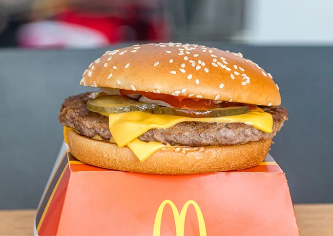 McDonald's cheeseburger placed on a cardboard box.