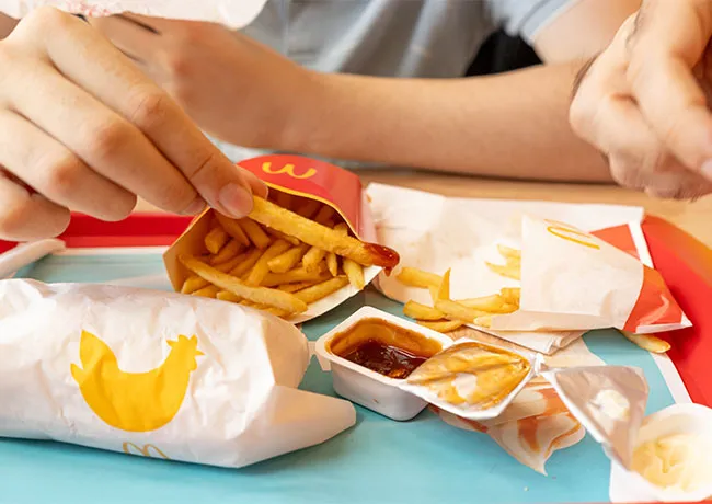 People enjoying McDonald's fries at a casual gathering.