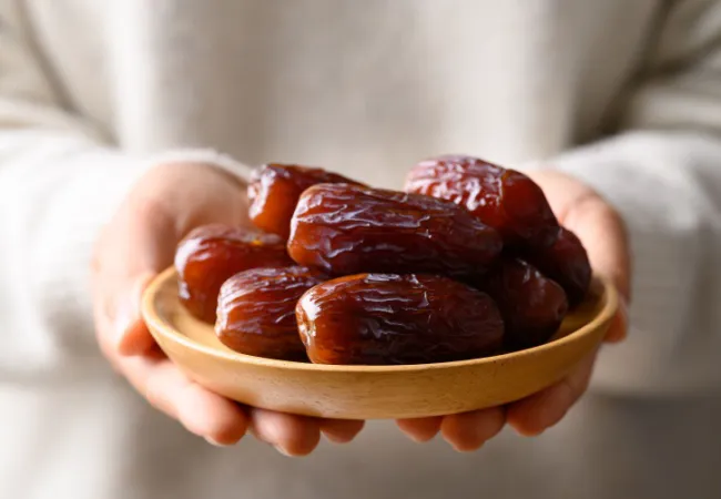 Delicious bowl of fresh dates on a wooden table