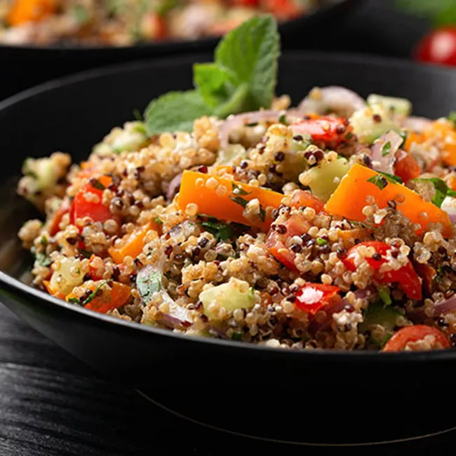Colorful quinoa vegetable salad in a bowl, ready to eat.