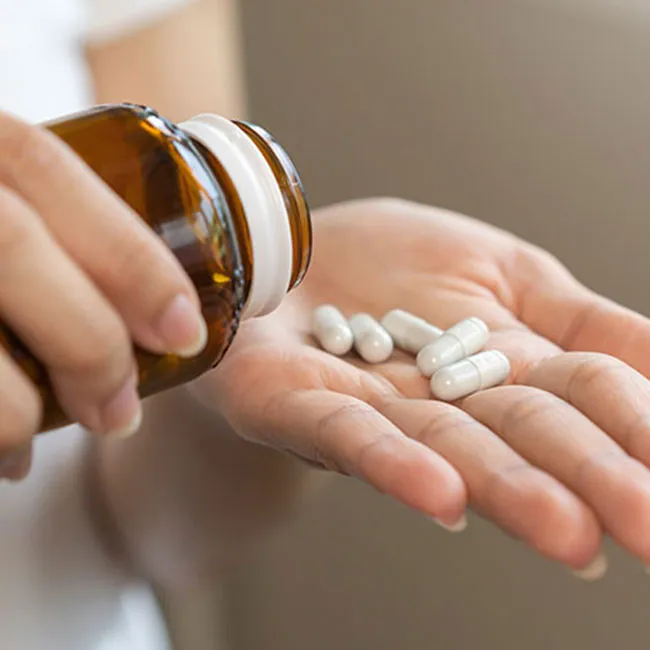 Woman dispensing dietary supplements for health and wellness.