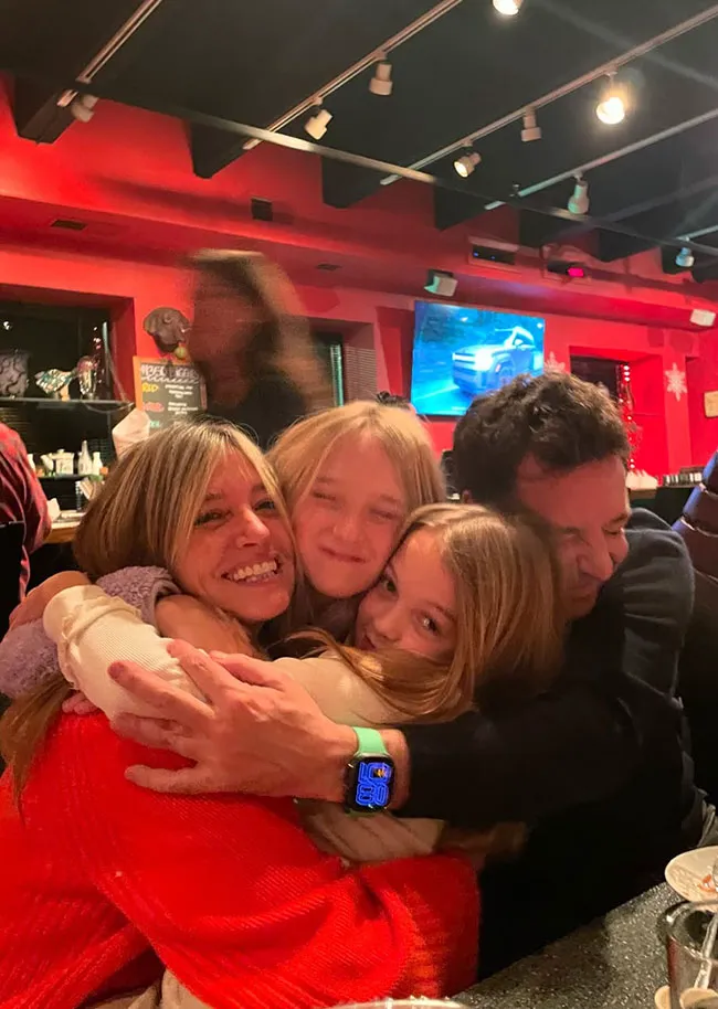 Jimmy Fallon and wife hugging daughters