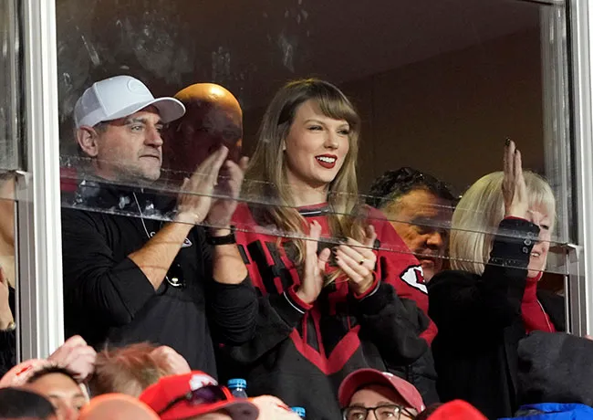 Taylor Swift at Chiefs game in stylish outfit, enjoying the event.