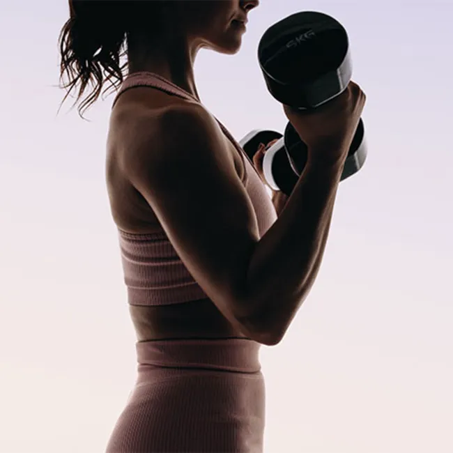 Woman lifting weights during a workout session.