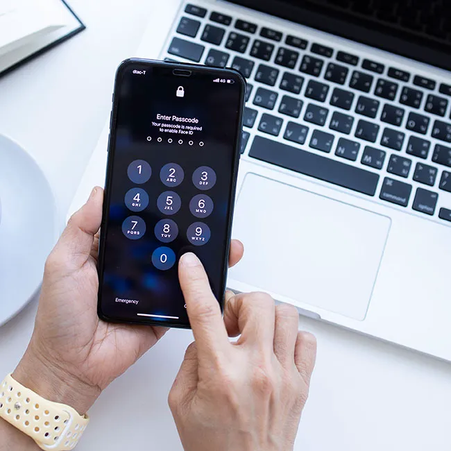 Woman entering password on her iPhone for secure access.