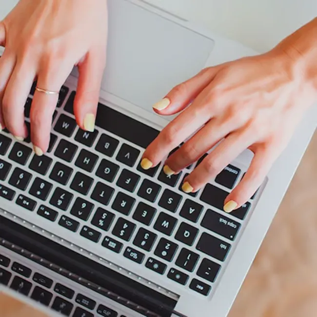 Person working on a laptop in a stylish home office.