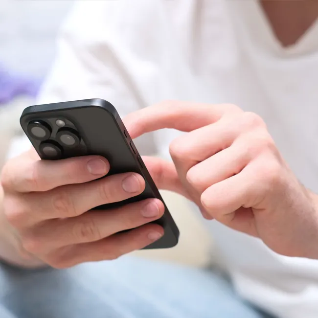Man using his smartphone while sitting in a cafe.