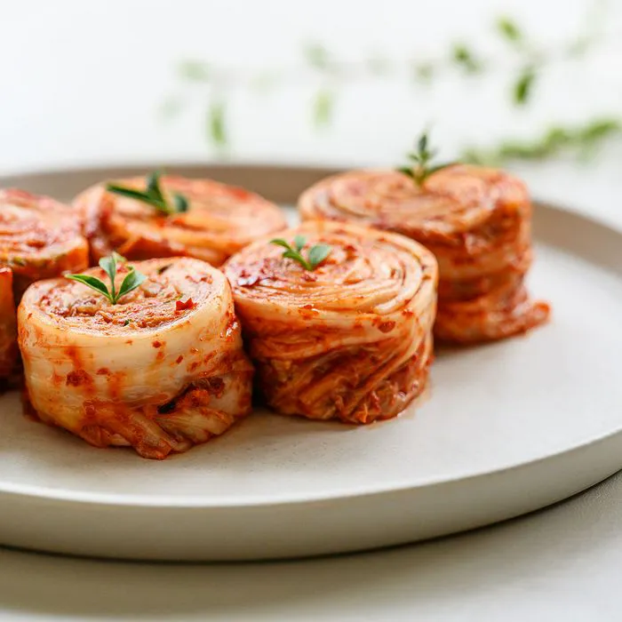 Plate of colorful kimchi rolls garnished with herbs