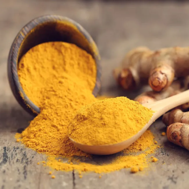 Fresh turmeric root on a wooden surface