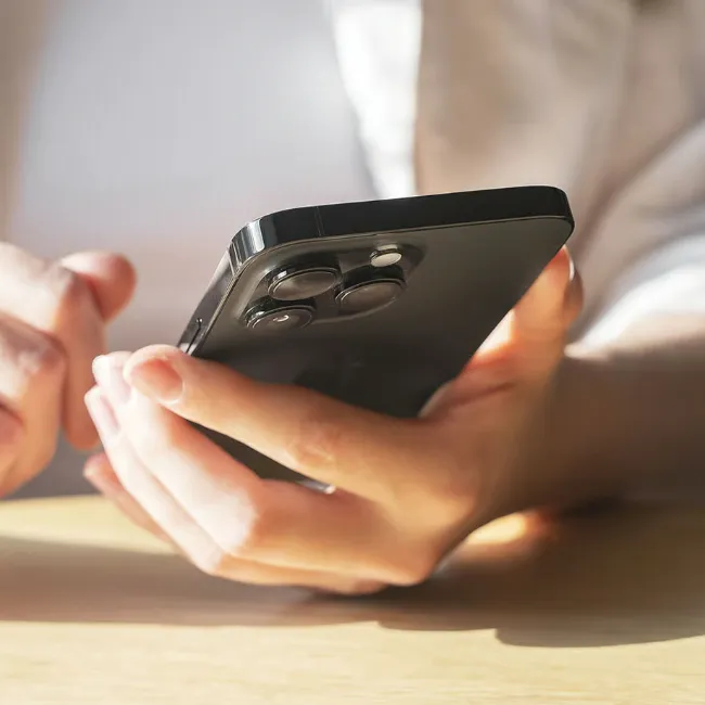 Person using a black iPhone outdoors