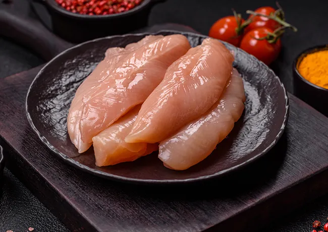 Raw chicken strips neatly arranged on a plate