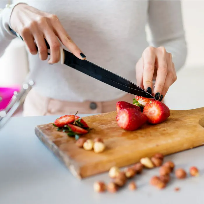 "Slicing fresh strawberries on a cutting board"