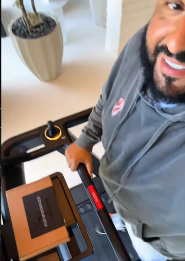 DJ Khaled running on a treadmill indoors.