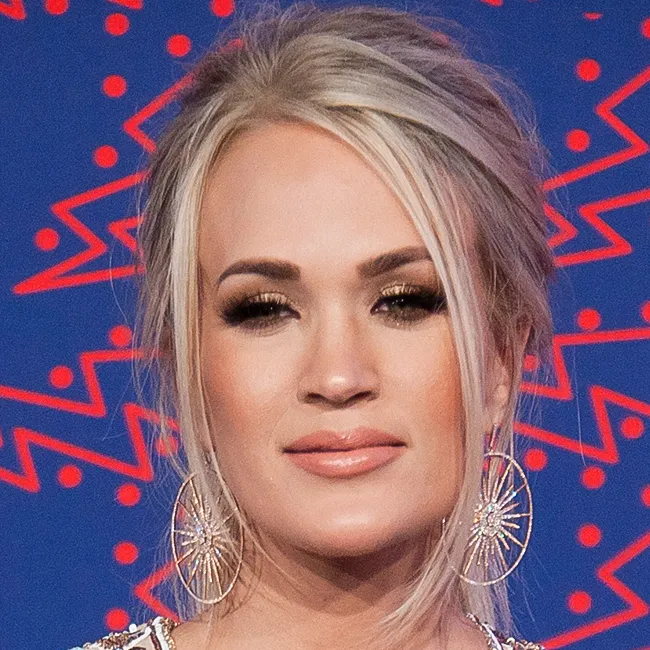 Carrie Underwood celebrating at music awards with stunning performance.