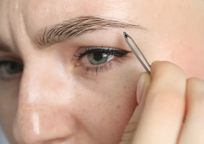 woman-tweezing-eyebrows