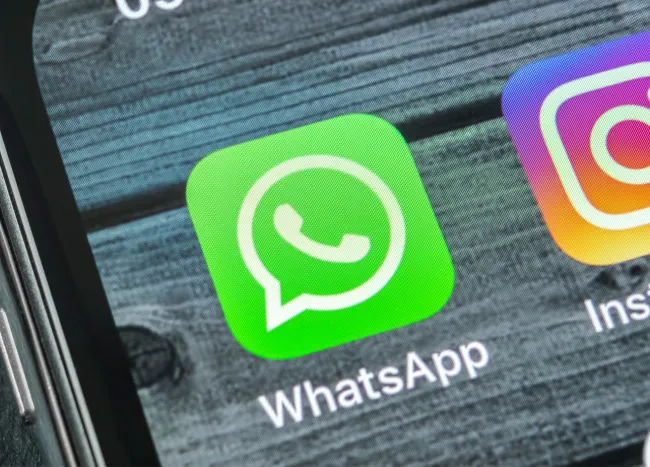 WhatsApp interface on iPhone with celebrity news updates.