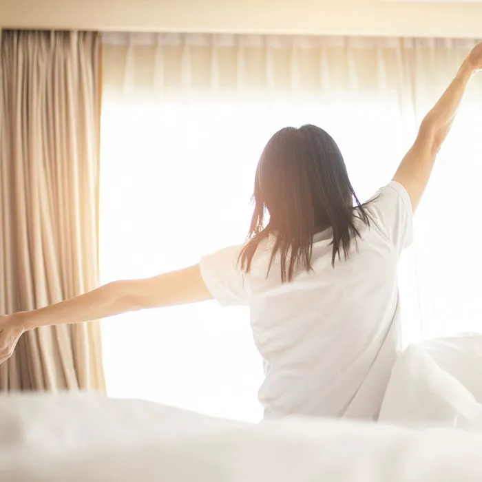 "Woman waking up and stretching"