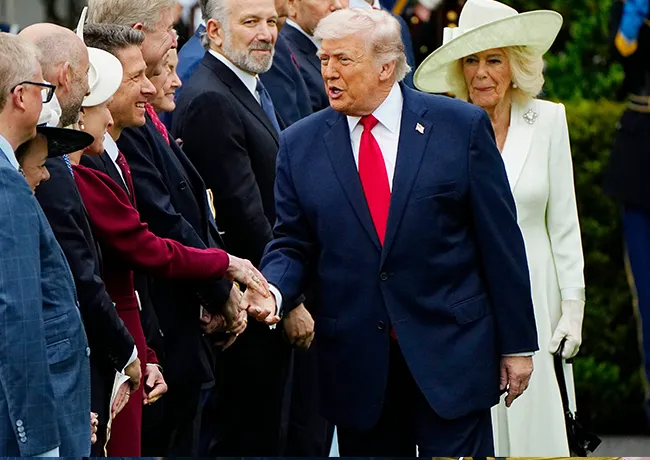 Donald Trump cutting in front of Queen Camilla shaking hands state visit